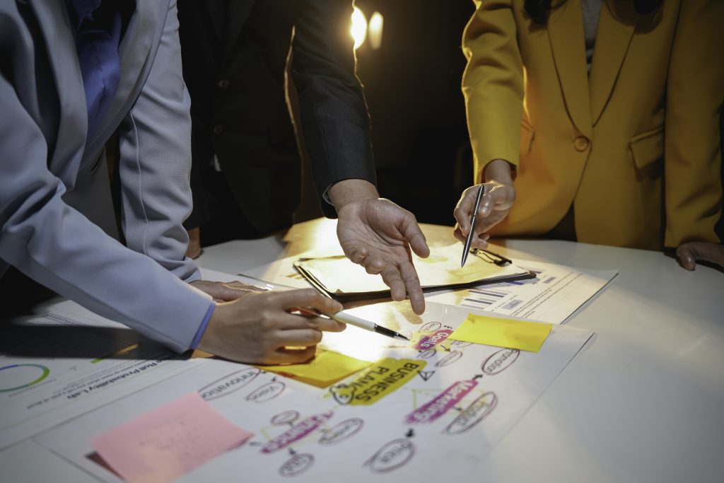 business team working late in the office using sticky notes and brainstorming new business plan